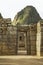 Wayna Picchu behind ruins of doors inside Machu Picchu