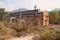 Wayside deserted 1970s` red brick buildings of boiler factory in weeds