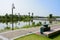 Wayside trash can and streetlamp at lakeside in city of sunny summer morning