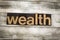 Wealth Letterpress Word on Wooden Background