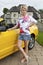 Wealthy young woman standing beside car