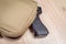 Weapon gun in bag, khaki or sand color, on table background