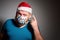 Wear a mask. Adult man in Christmas decorated mask celebrate xmas holidays at home because coronavirus.