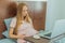 Weary pregnant woman, tired of working from home, navigates the challenges of balancing professional tasks with