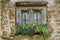 Weather-beaten wooden window with flower decoration