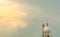 Weather observations radar dome station and telecommunication tower against blue sky and clouds. Aeronautical meteorological