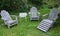 Weathered Adirondack chairs on green lawn