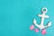 Weathered anchor with seashells on a turquoise glitter background