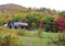 A WEATHERED BARN IN A FIELD AND COLORFUL FALL FOLIAGE