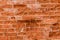 A weathered broken red brick wall