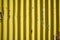 Weathered corrugated yellow rusty metal wall.