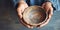 Weathered hands holding an empty bowl , concept of Resilience