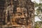 Weathered, Lichen-covered Stone Head Statue in Angkor Wat, Siem Reap, Cambodia, Indochina, Asia - face on in colour