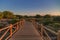 Weathered lumber path leading to calm sea during beautiful sunset