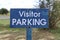 Weathered metal blue and white Visitor Parking sign