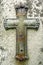 Weathered metal crucifix on vintage gravestone