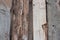 Weathered old wooden wall detail. Simple gray boards with knotholes and coarse grain nailed together. Outdoor. Backgrounds. Photo