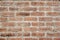 Weathered orange brick wall photo for background. Brickwork closeup. Old rustic brick masonry.