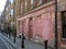 Weathered red - pink painted traditional Huguenot house in Princelet Street, Spitalfields, East London, UK.