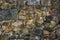 Weathered stone wall of large cobblestones overgrown with moss