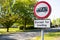 Weathered traffic loading sign seen near a quiet residential area set in a rural location.