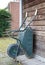 Weathered wheelbarrow leaning against a wooden wall