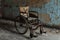 A weathered wheelchair is left forgotten in a rundown and deteriorated room, An old rusty wheelchair in an abandoned hospital, AI