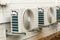 Weathered White Airconditioning Units Mounted on Exterior Home W