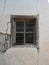 Weathered Window with Metal Bars in Crumbling Concrete Wall