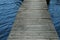 Weathered wood dock leading across the lake - passing stormy waters