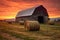 weathered wooden barn with hay bales at sunset