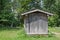 Weathered wooden shed in a meadow on the edge of a forest