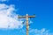 Weathered wooden utility pole with parallel single-circuit lines and colorful isolators in the blue sky