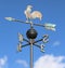 weathervane with rooster above an arrow and the four cardinal p