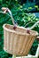 Weaved basket in front of foldable bicycle with plant background