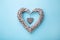 Weaved wooden heart on blue background, top view