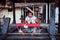 Weaver young woman behind a loom, handmade manufacturing fabric and carpets