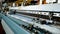 weaving looms. weaving factory. textile industry. Close-up. Automated weaving machine is fabricating cloth of threads