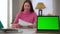Web page mockup on green screen laptop on the right with blurred unsatisfied woman arguing leaving at background
