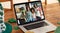 Webcam view of group of friends at a bar on video call on laptop on wooden table