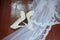 Wedding accessories. Bridal shoes  and veil on the wooden floor at wedding morning preparation