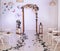 Wedding arch decorated with flowers. Large candlesticks with candles in the room with decor. Wedding ceremony