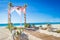 wedding arch decorated with flowers on tropical sand beach, outdoor beach wedding setup