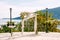 Wedding arch decorated with roses and white cloth stands on the embankment above the sea