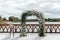 Wedding arch decorated with white flowers at the background of the river. Outside wedding ceremony place