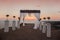 wedding arch with flower arrangement with white curtain on sunset, outdoor photo. decor. Wedding ceremony.