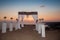 wedding arch with flower arrangement with white curtain on sunset, outdoor photo. decor. Wedding ceremony.