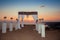 wedding arch with flower arrangement with white curtain on sunset, sunrise outdoor photo. decor. Wedding ceremony.
