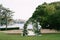 Wedding arches surrounded by rows of chairs on a green lawn near the sea