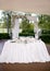 The wedding banquet table of the newlyweds is decorated with an arch of flowers and high candlesticks with candles